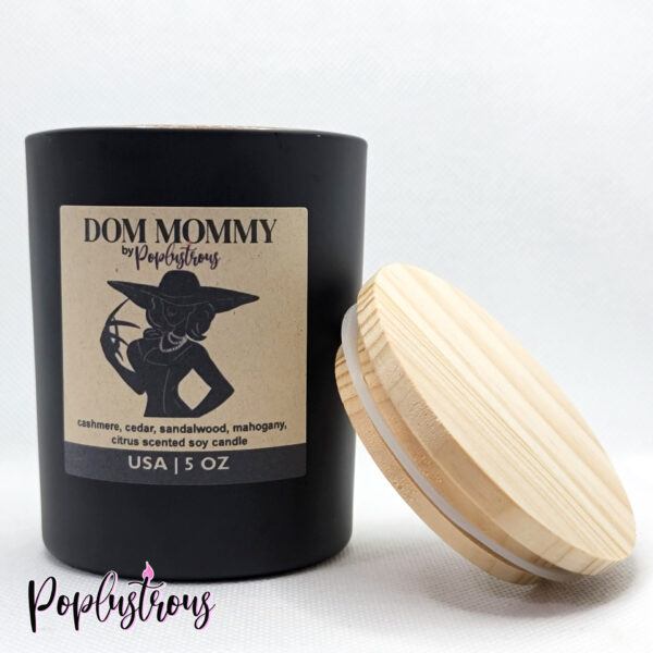 Dom Mommy candle by PopLustrous- Cashmere, Cedar, Sandalwood, Mahogany, Sweet Orange. Resident Evil themed Lady Dimitrescu Soy Candle, displayed without the wooden lid placed on the black glass candle jar.